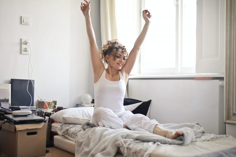 Woman Sitting In the Bed and Having Morning Stretch